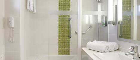 A modern bathroom with a glass-enclosed shower, a white sink, and a mirror.
