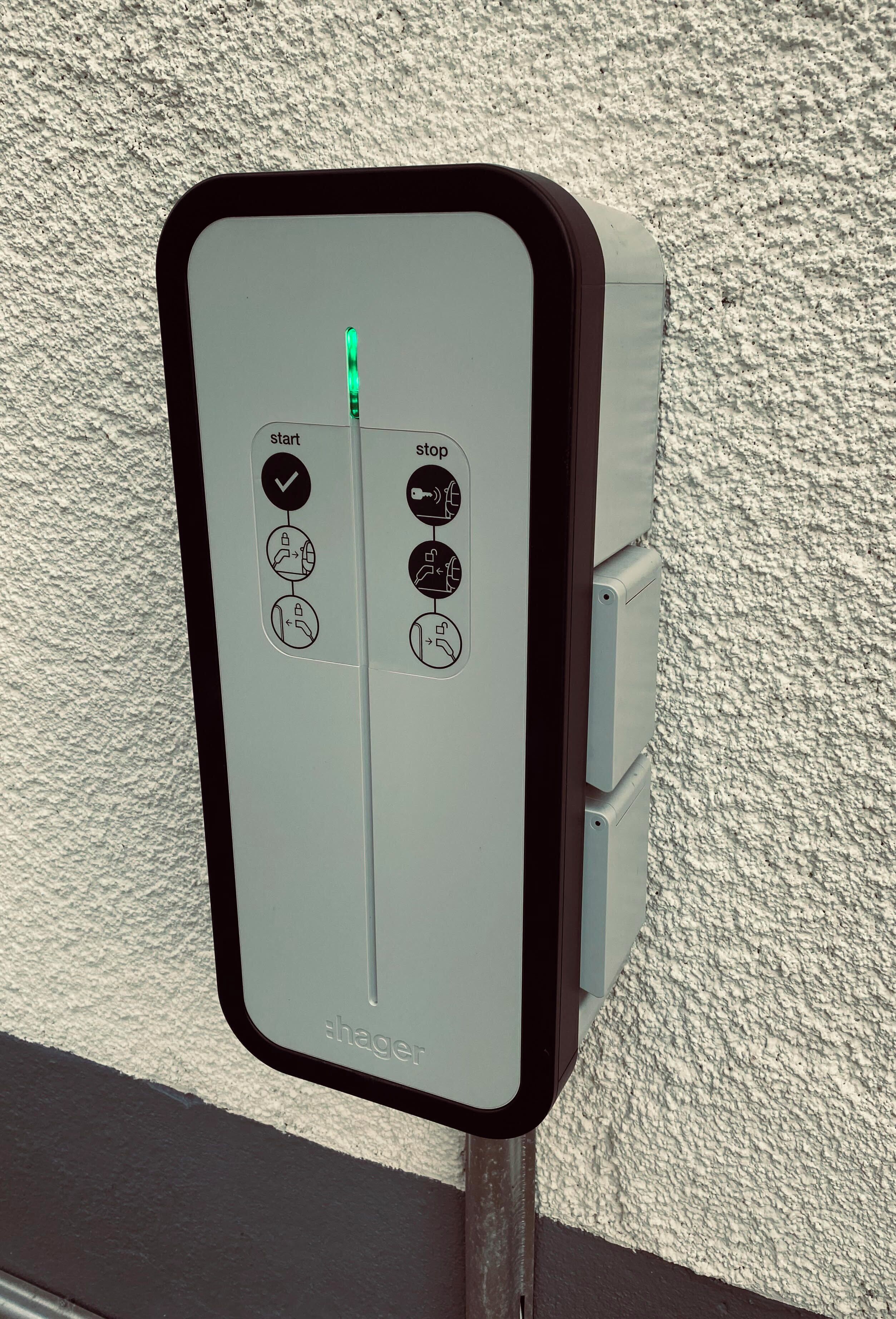 A control panel with start and stop buttons, a green indicator light, and a brand name 'hager'.