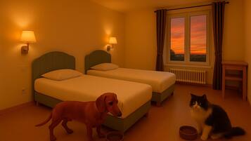 Quarto de hotel com duas camas, janela com cortinas, radiador, mesa pequena e um cão e um gato.