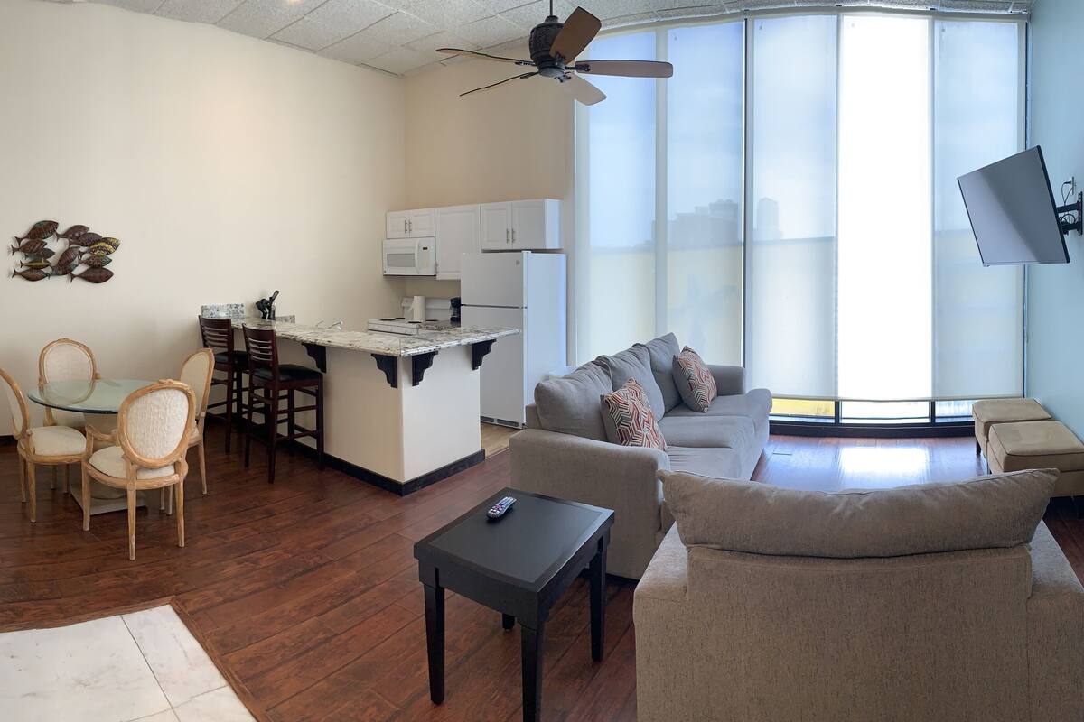 A compact living space with a dining area, kitchenette, and seating area.