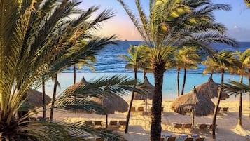 Privat strand, hvit sand, solsenger og parasoller