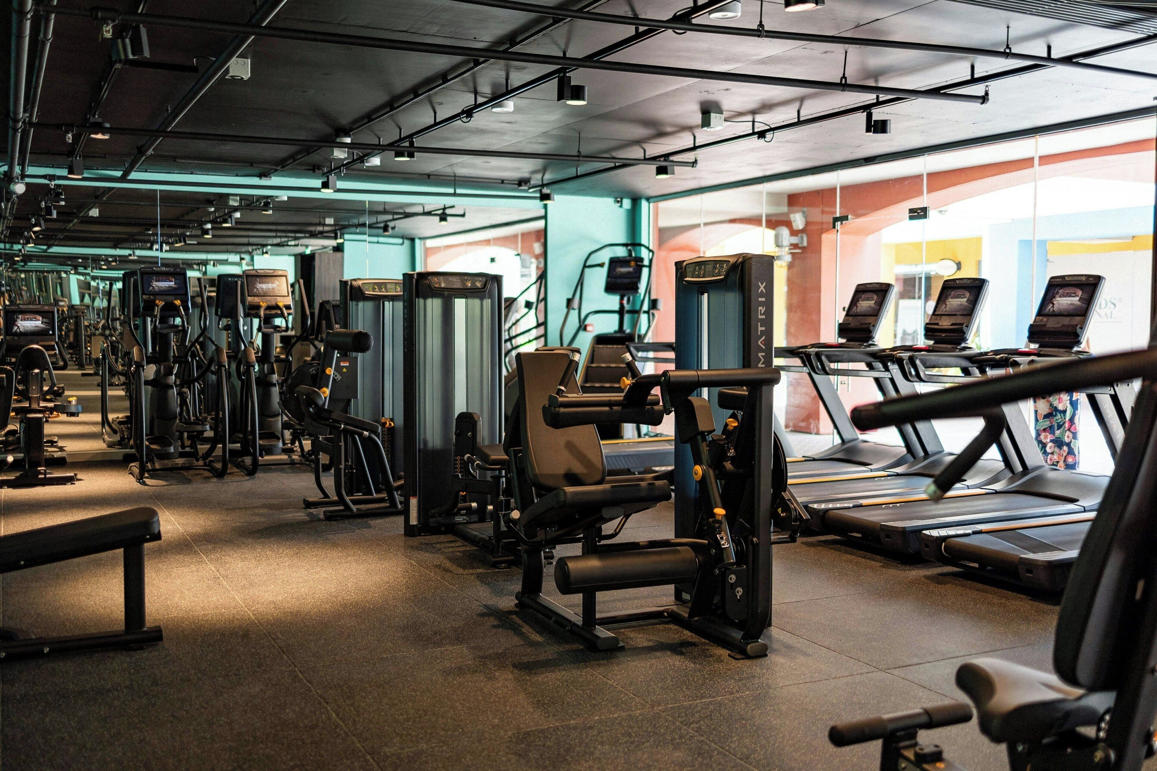 A gym with various exercise equipment, treadmills, and weight machines.