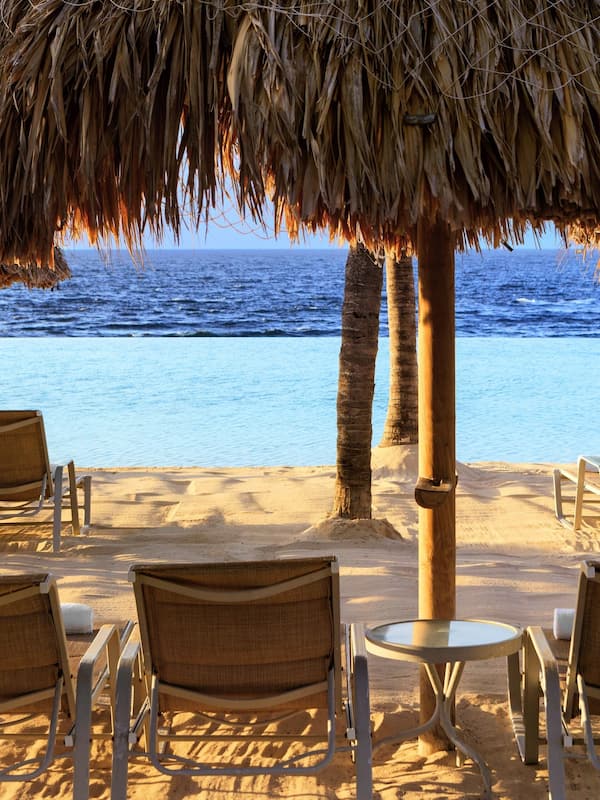 Playa privada, playa de arena blanca, camastros y sombrillas