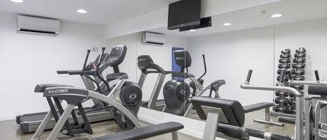 A gym with treadmills, a bench, and weight machines.