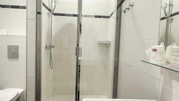A modern bathroom with a glass-enclosed shower, a white sink, and a bathtub.