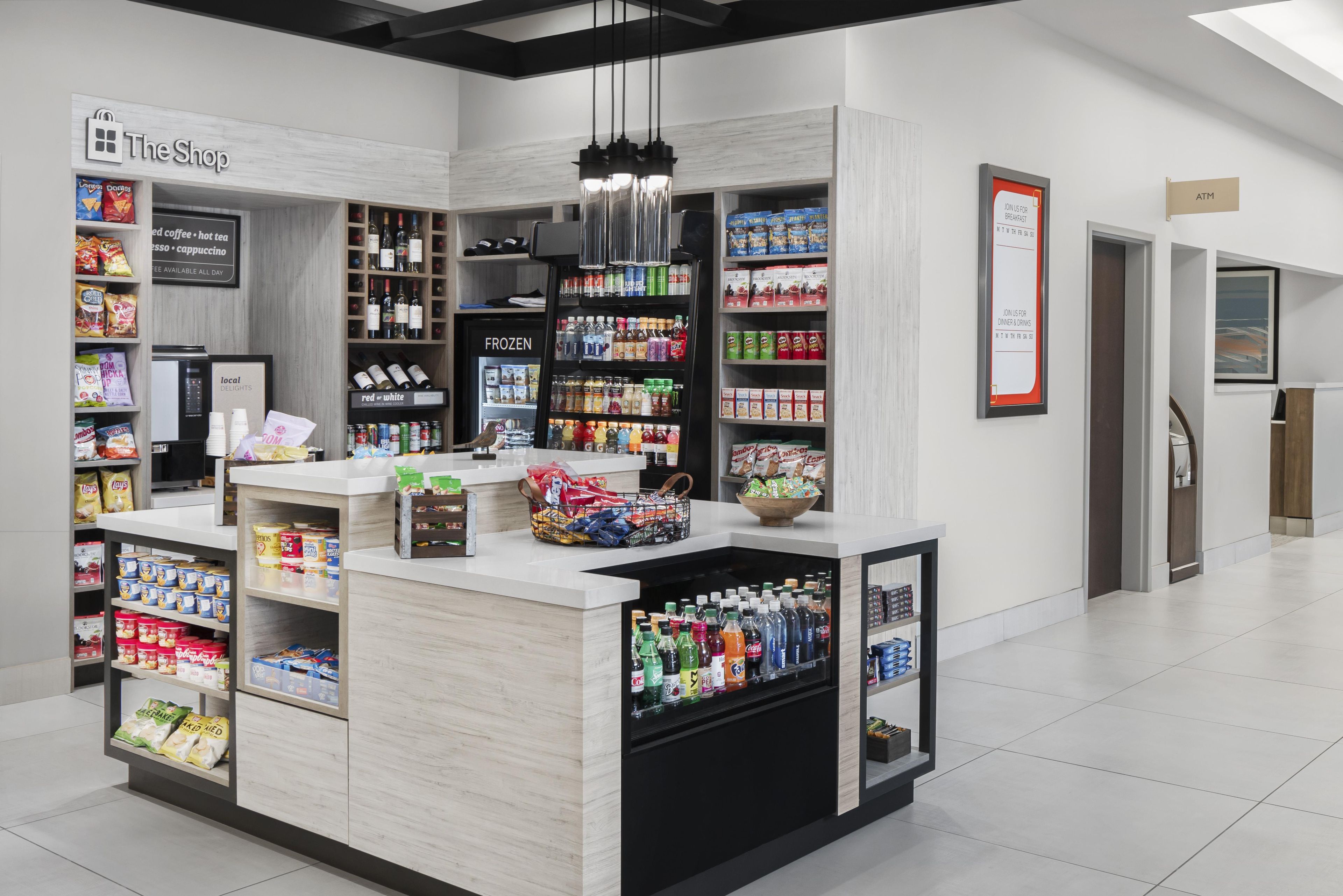 A modern retail space with a coffee station, snack shelves, and a beverage display.