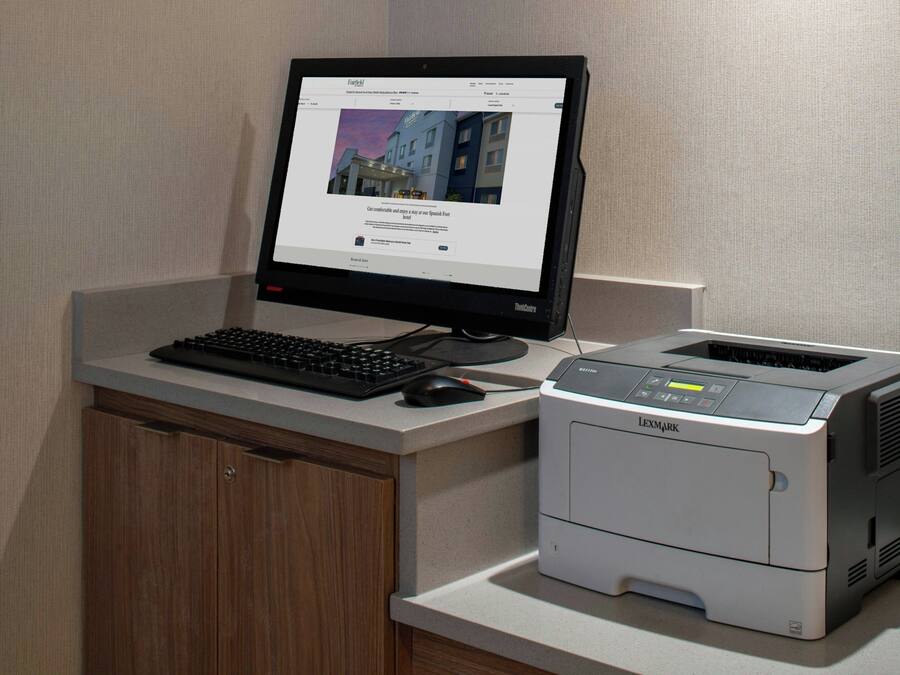 Työpöydällä on pöytätietokone, jossa on näyttö, näppäimistö ja hiiri, sekä Lexmark-merkkinen tulostin.