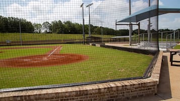 A baseball field with a brick wall and a covered seating area.