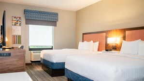 A hotel room with two beds, a desk, a TV, and a window with a view. - Hampton Inn Gonzales (Gonzales)