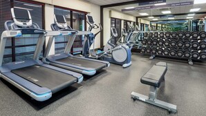 A gym with treadmills, elliptical machines, and a bench. - Hampton Inn Springfield South Enfield (Enfield)