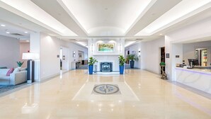 Un hall d’entrée spacieux, doté d’un sol ciré, d’un comptoir de réception et d’une cheminée.