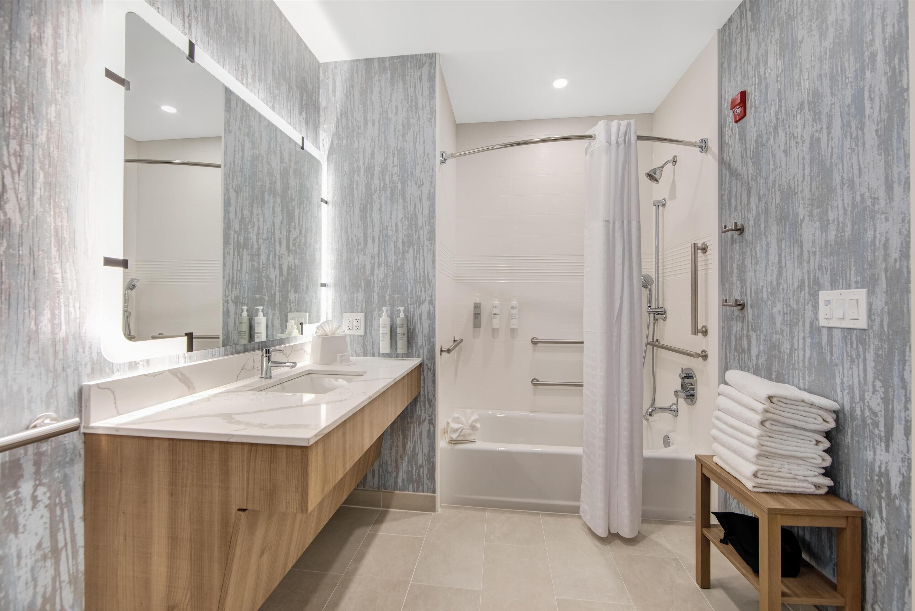 Un baño moderno con tocador doble, ducha a pie y bañera.