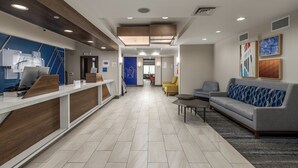 A modern reception area with a reception desk, seating area, and a hallway leading to other rooms. - Holiday Inn Express Hotel & Suites Vancouver Mall by IHG (Vancouver)