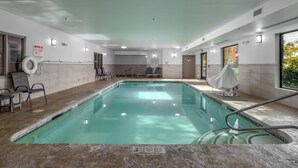 An indoor swimming pool with clear water, surrounded by lounge chairs and a lifeguard stand. - Holiday Inn Express Hotel & Suites Vancouver Mall by IHG (Vancouver)