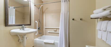 Une salle de bain équipée d’un lavabo, d’un miroir, d’une douche et d’une baignoire.