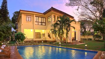Relax by the pool surrounded by lush greenery and enjoy the warm ambiance.