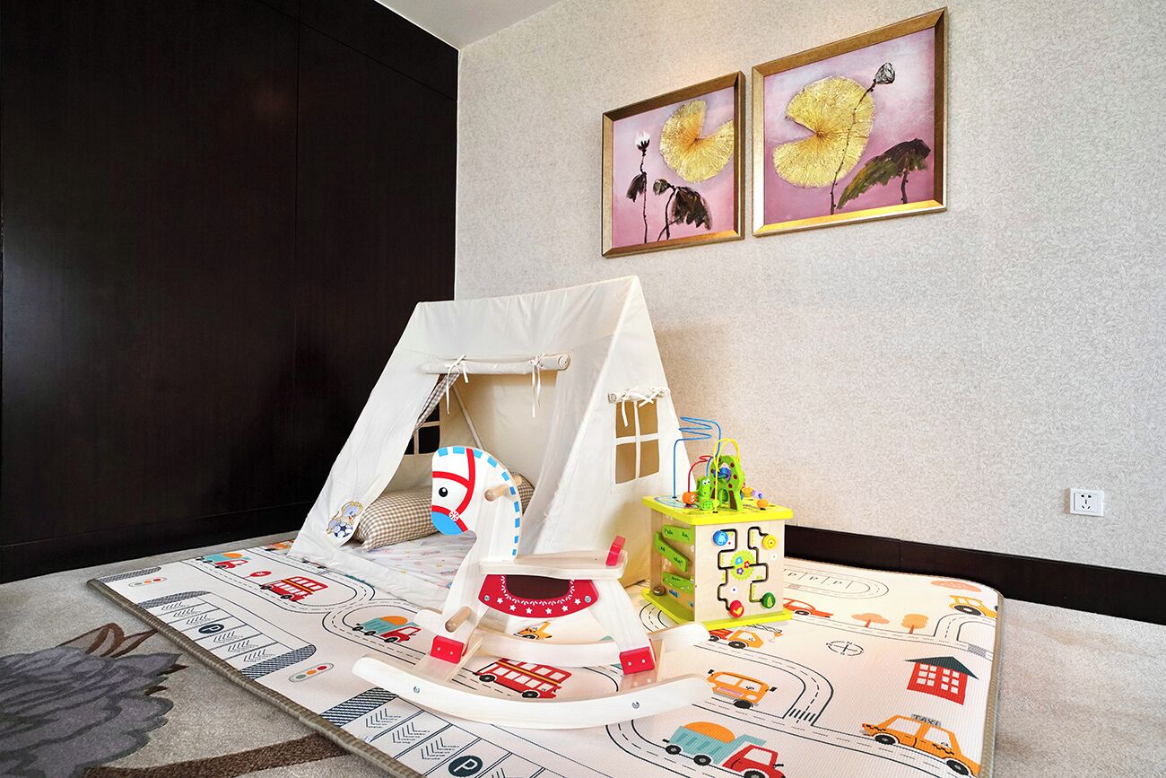 Een speelruimte met een tent, een klimconstructie en een treinbaan.