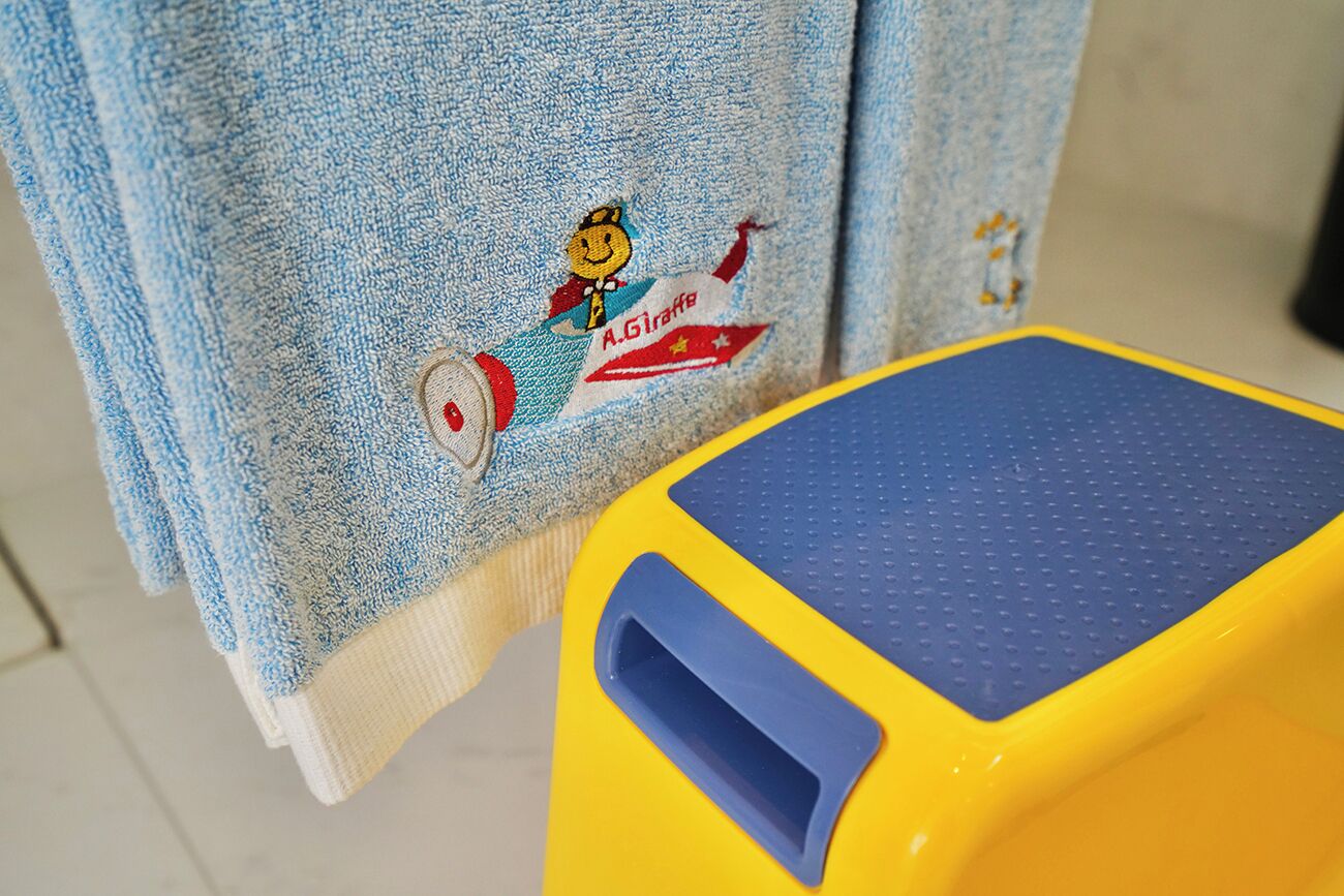 A blue towel with a cartoon character and the text "A.Girafe" embroidered on it.