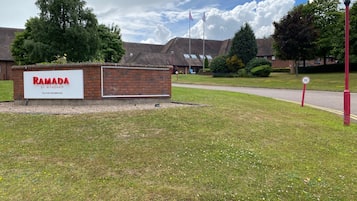 Welcome to Ramada by Wyndham Telford Ironbridge, situated in a scenic area with a grassy landscape and a nearby building.