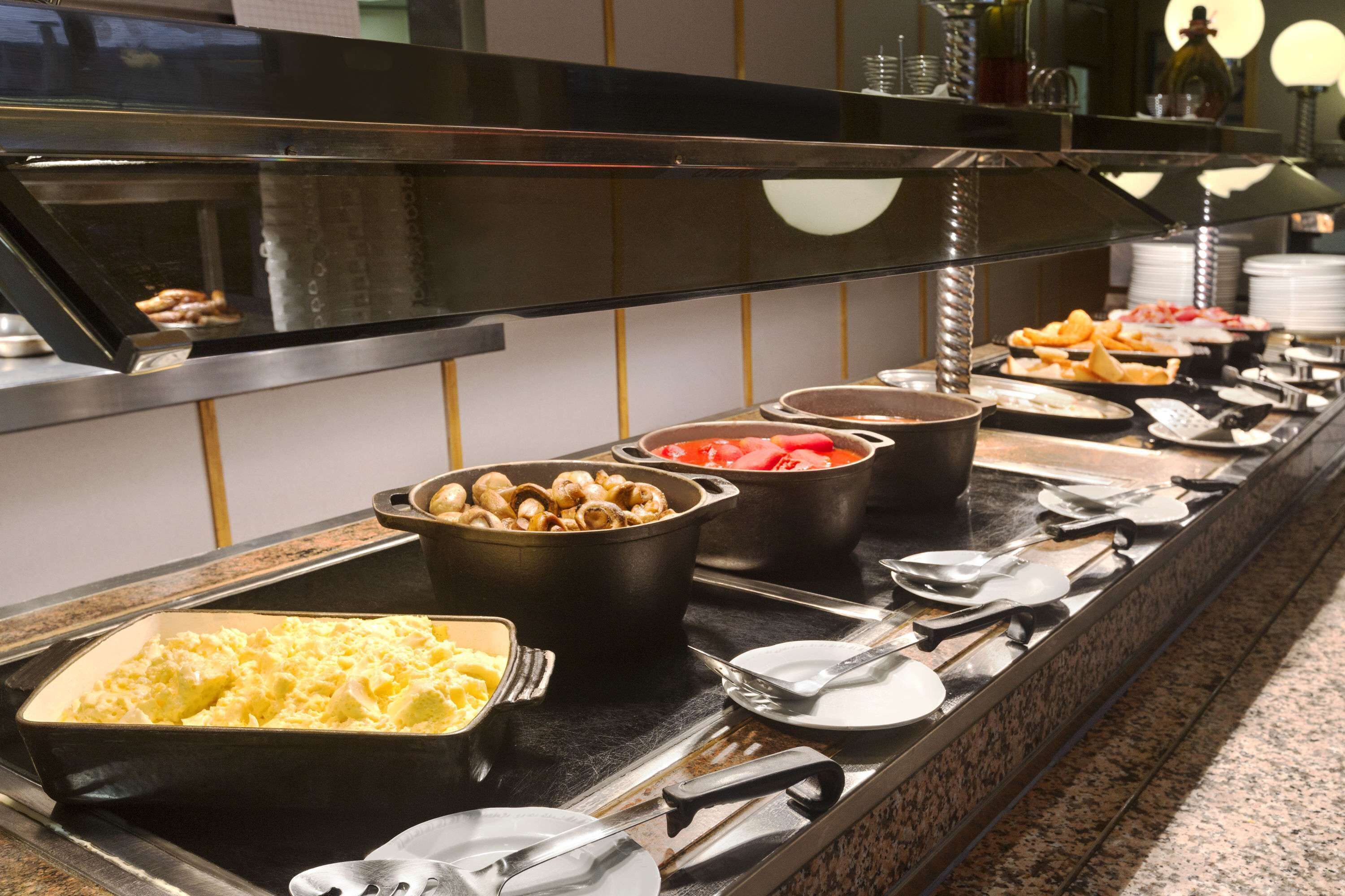 A buffet with various food items including pasta, vegetables, and meats.