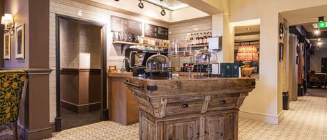 A kitchen with a wooden island, a refrigerator, and a coffee machine.