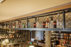 Un espace bar doté d’un assortiment de bouteilles d’alcool, d’un système de distribution en fût et d’un terminal de paiement numérique.