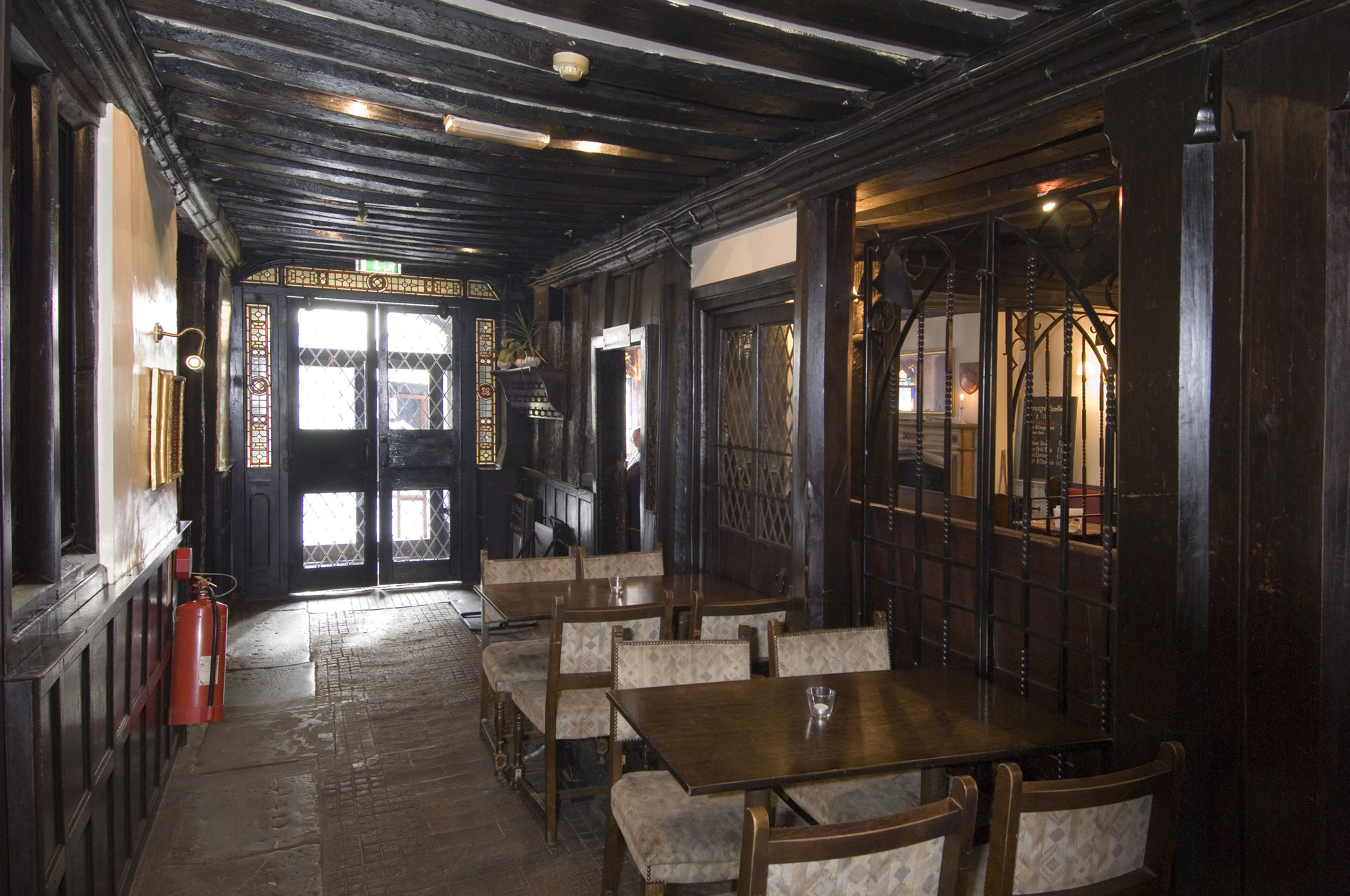 Un interior tradicional con muebles de madera, un extintor y una puerta con diseño.