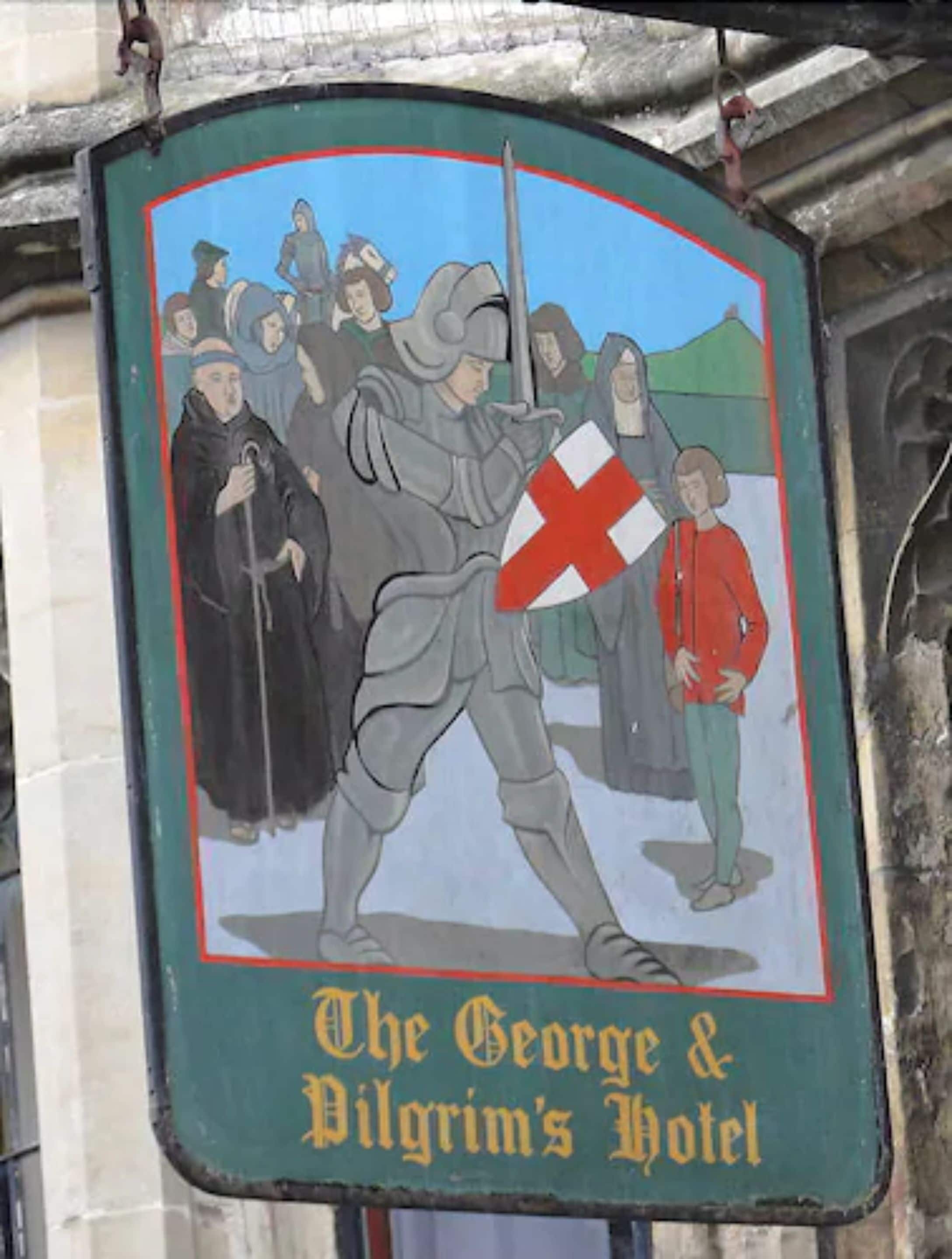 A sign for The George & Pilgrim's Hotel featuring a knight and a shield.