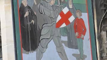 A sign for The George & Pilgrim's Hotel featuring a knight and a shield.