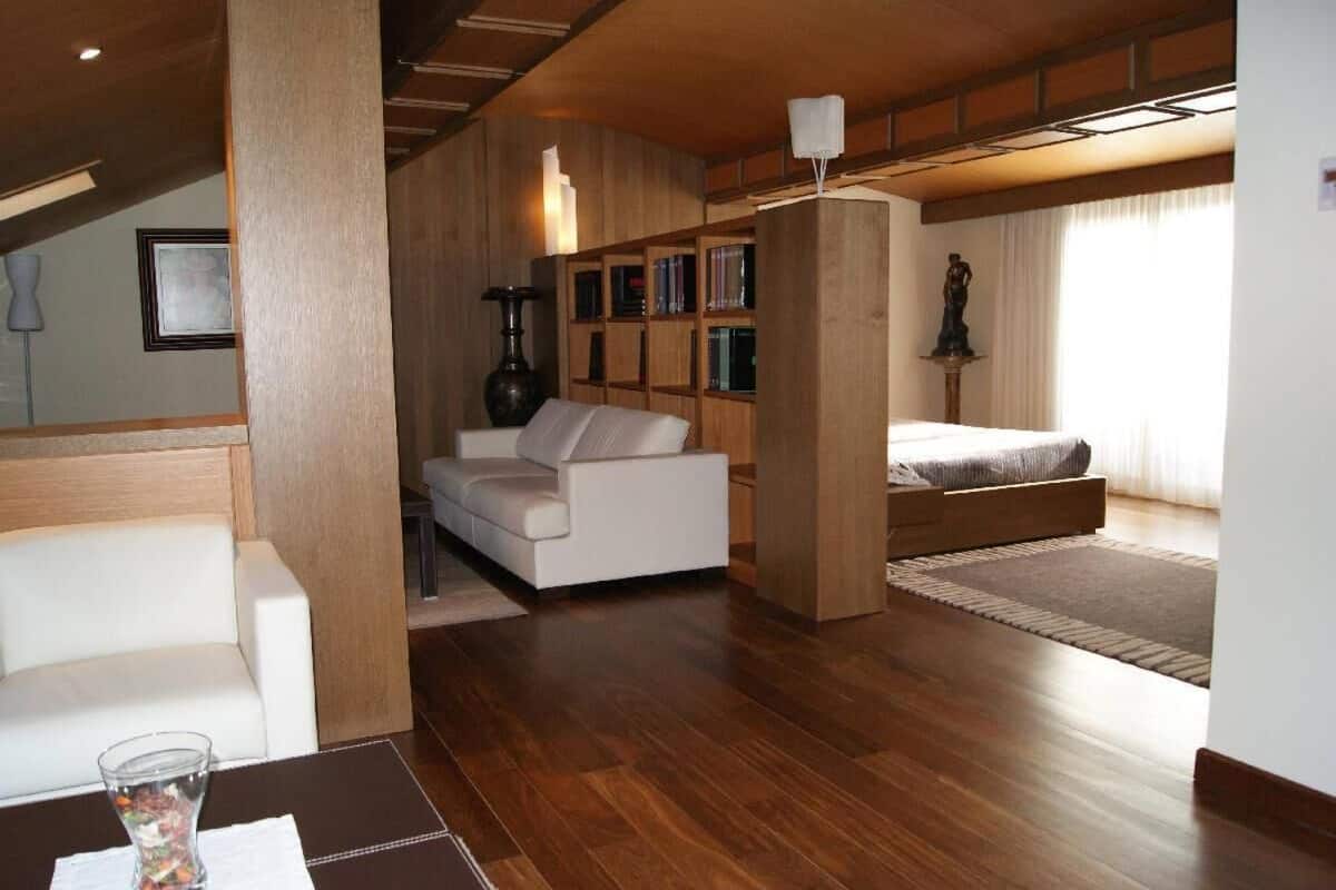 Una sala de estar moderna con un sofá, una mesa de centro, una estantería y una estatua.
