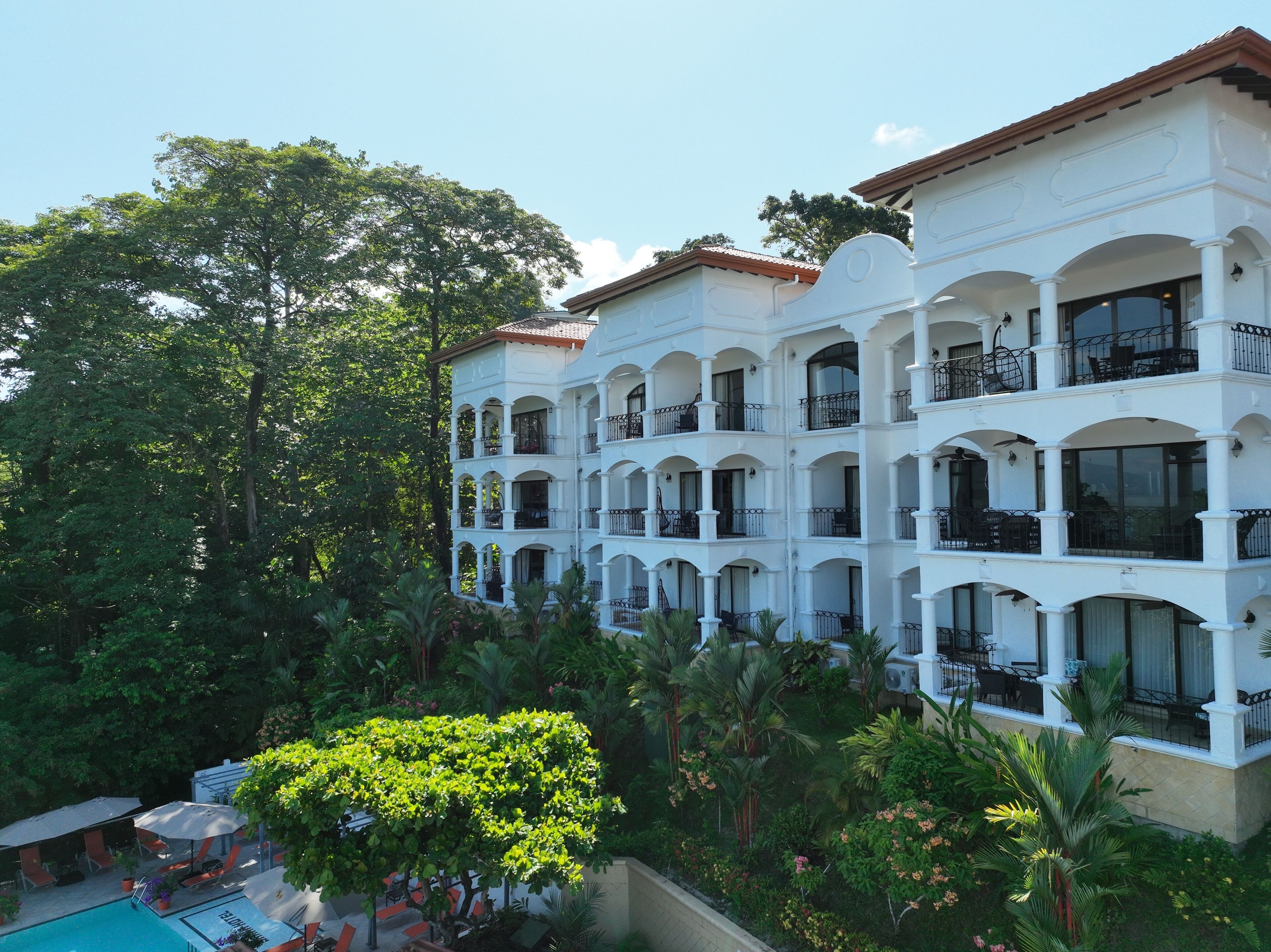 A multi-story hotel with balconies and a pool area.
