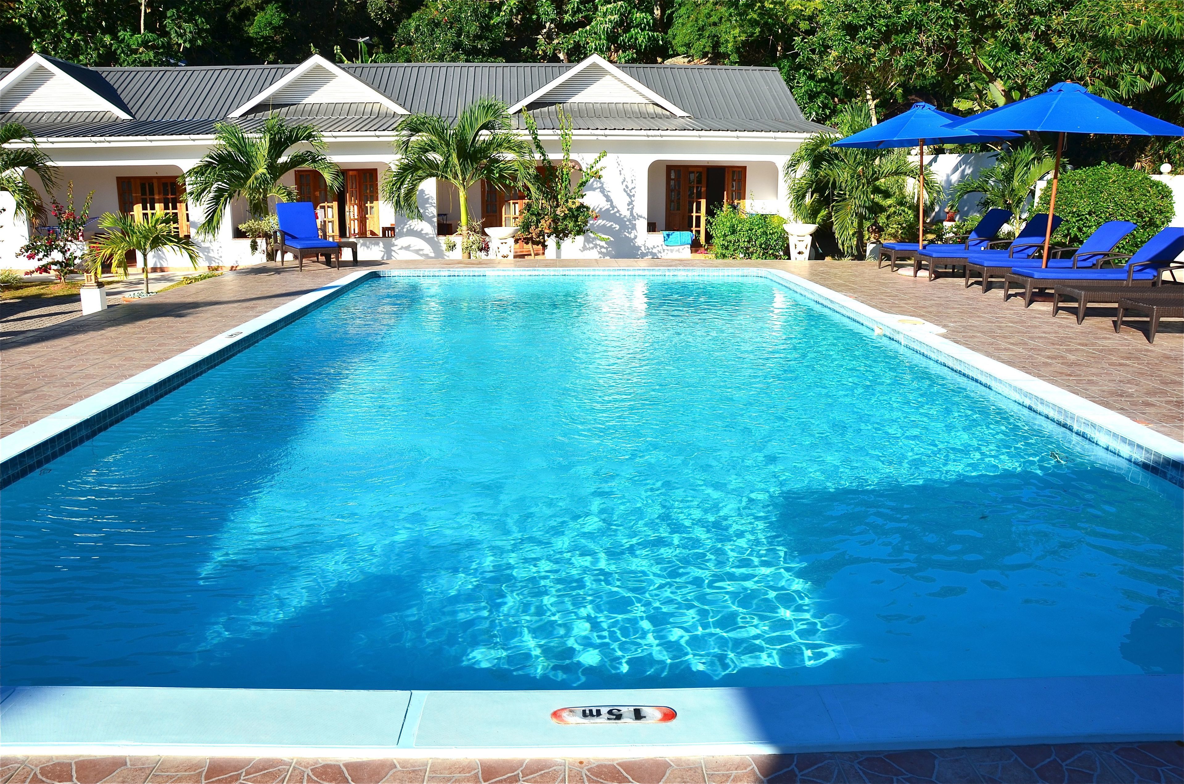 Una piscina al aire libre, sillones reclinables de piscina