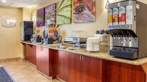 Un'area reception di un hotel con una macchina da caffè, una bilancia, un forno a microonde e un frigorifero.