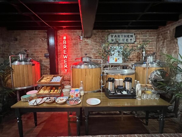Une table en bois, des machines à café et une pancarte indiquant « VARTHEN SKEET » : voilà ce qui compose l’espace réservé au petit-déjeuner.
