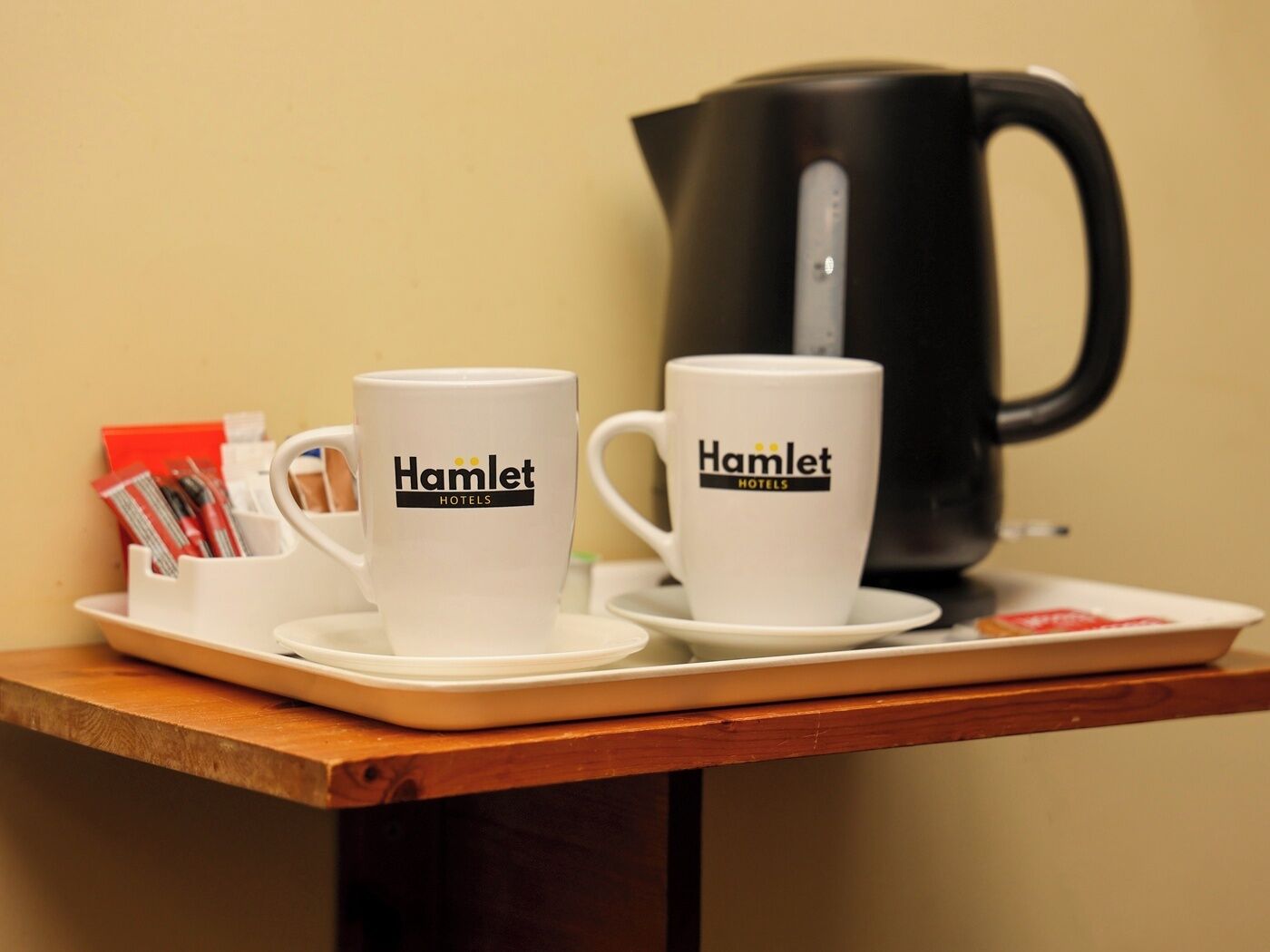 Two white mugs with 'Hamlet Hotels' branding on a tray.