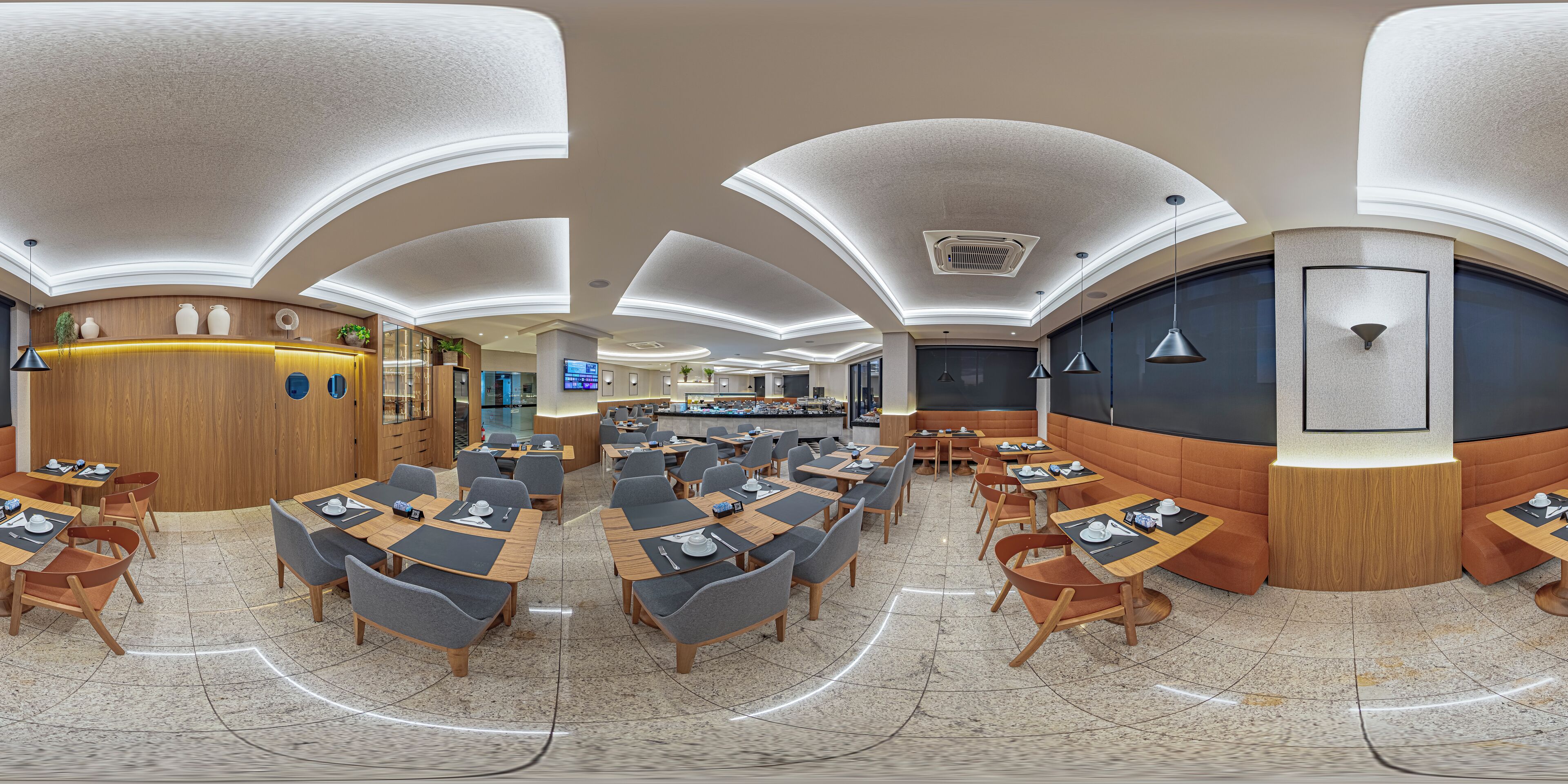 Un restaurante moderno con techo curvo, varias zonas de comedor y una barra.