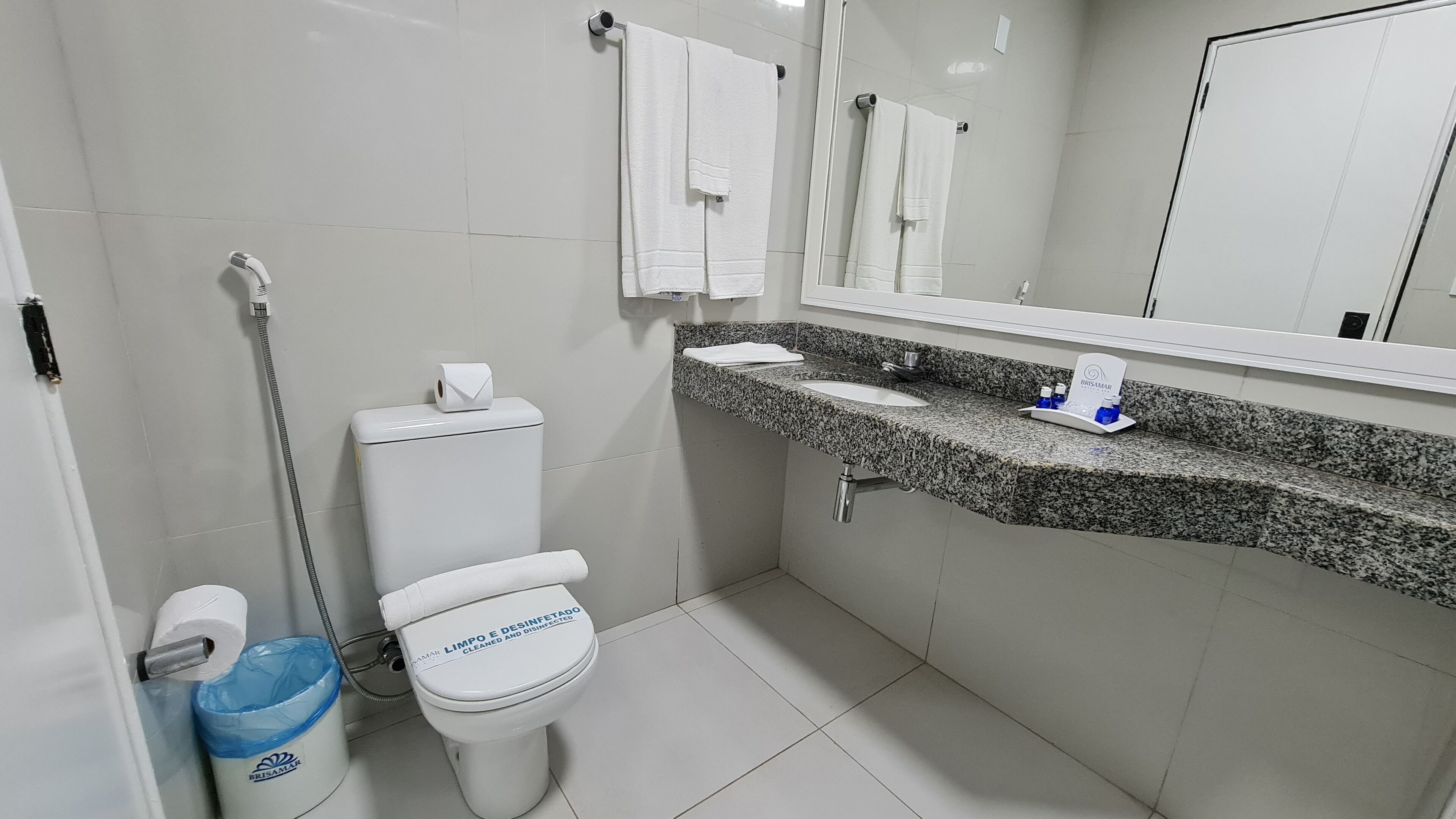 Un baño moderno con inodoro, lavamanos y ducha.