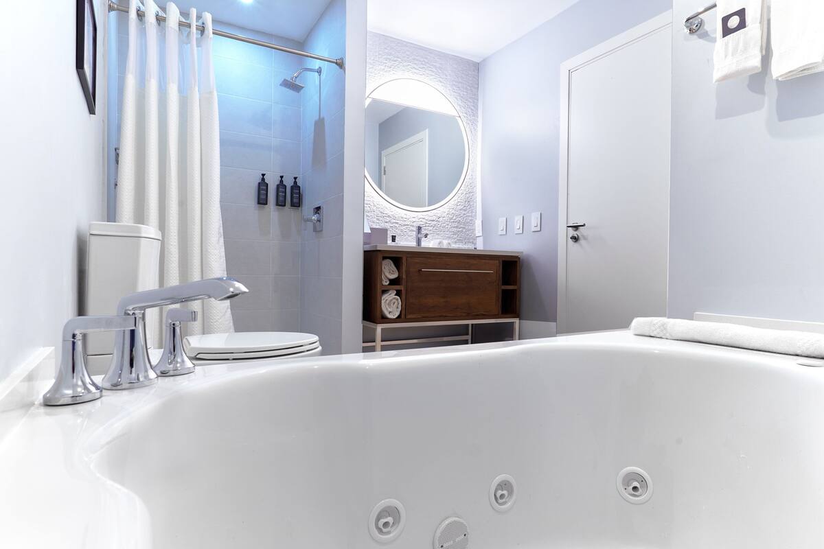 A modern bathroom with a large bathtub, a shower, and a vanity with a mirror.