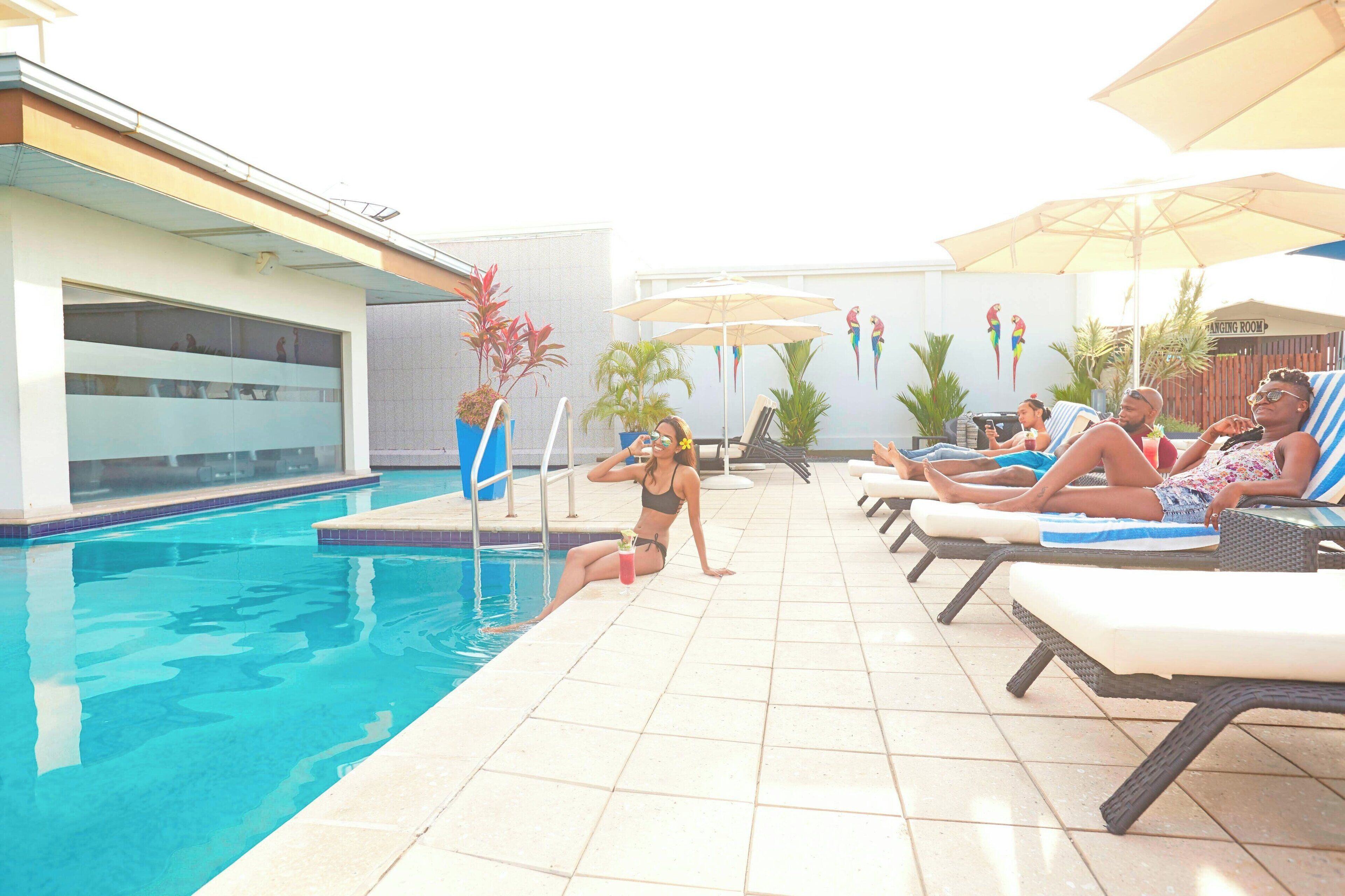 A poolside area with lounge chairs and umbrellas, a swimming pool, and a 'Flinging Room' sign.