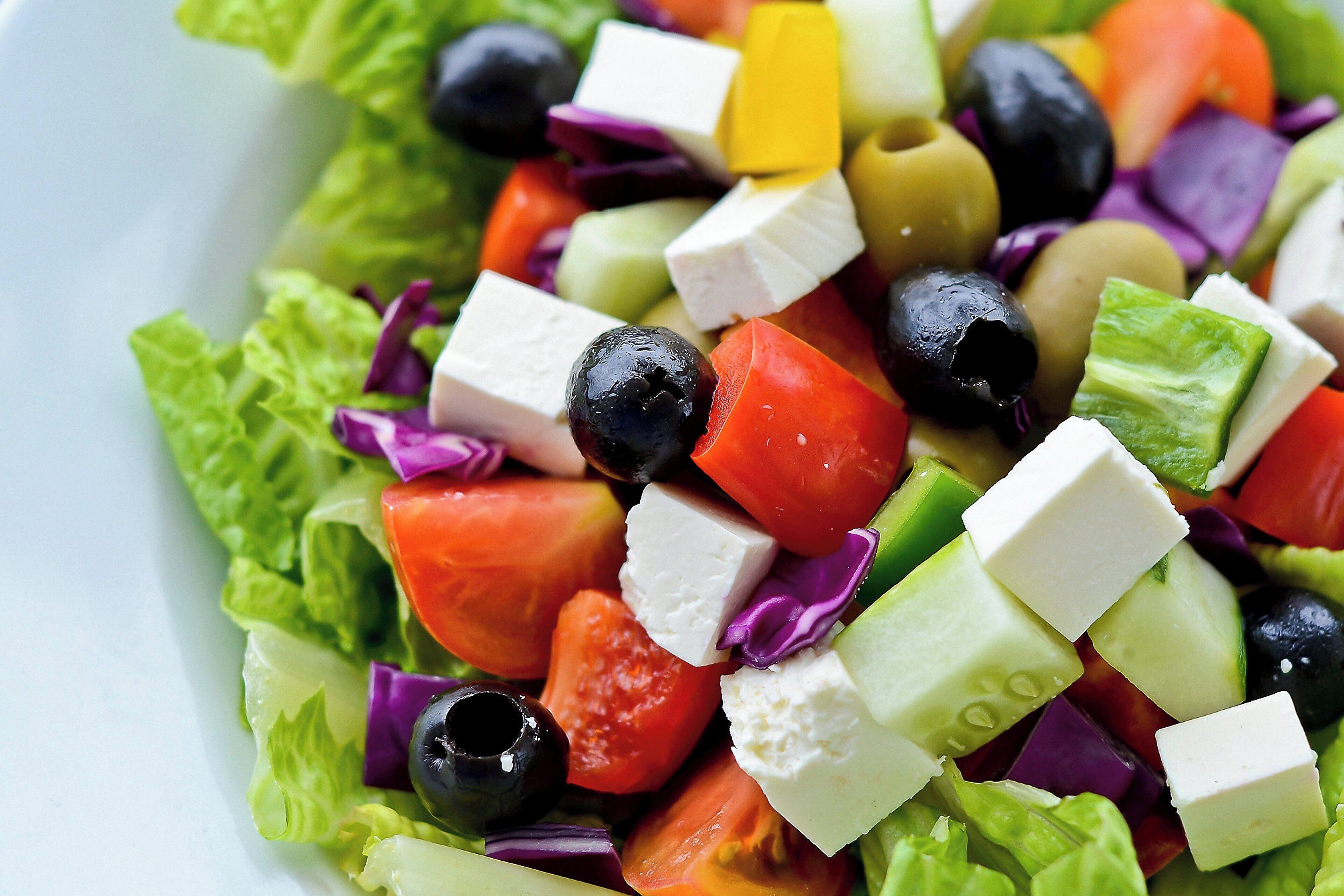 A salad with various vegetables and cheese.