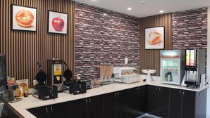Cozinha moderna com máquina de waffle, cafeteira e geladeira.