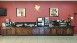 A breakfast bar with a coffee machine, tea station, and various food items. - La Quinta Inn & Suites by Wyndham Alice (Alice)