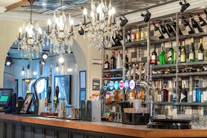 A bar area with a wine and liquor shelf, a cash register, and a bar counter. - The Kings Arms and Royal Hotel, Godalming, Surrey (Godalming)