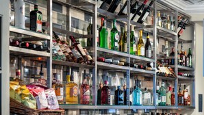 A bar area with shelves stocked with various liquor bottles and glasses. - The Kings Arms and Royal Hotel, Godalming, Surrey (Godalming)