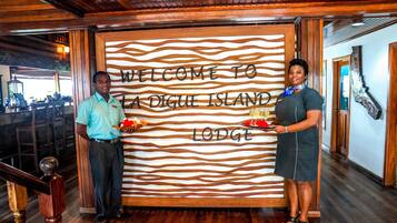 A wooden interior with a welcome sign for La Digue Island Lodge.