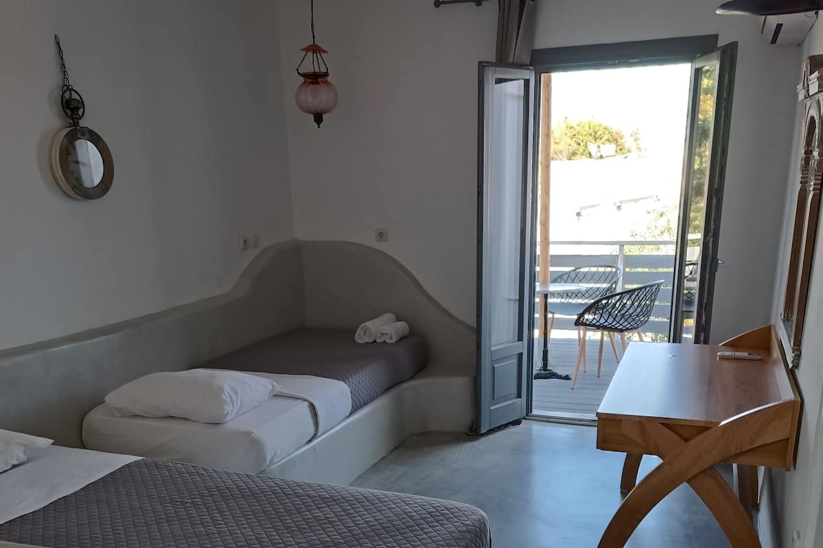 Un dormitorio moderno con cama, escritorio y vistas al exterior.