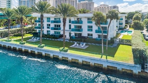 A modern hotel with multiple floors, a pool, and a view of the water. - Beach Haus Bal Harbour (Bal Harbour)