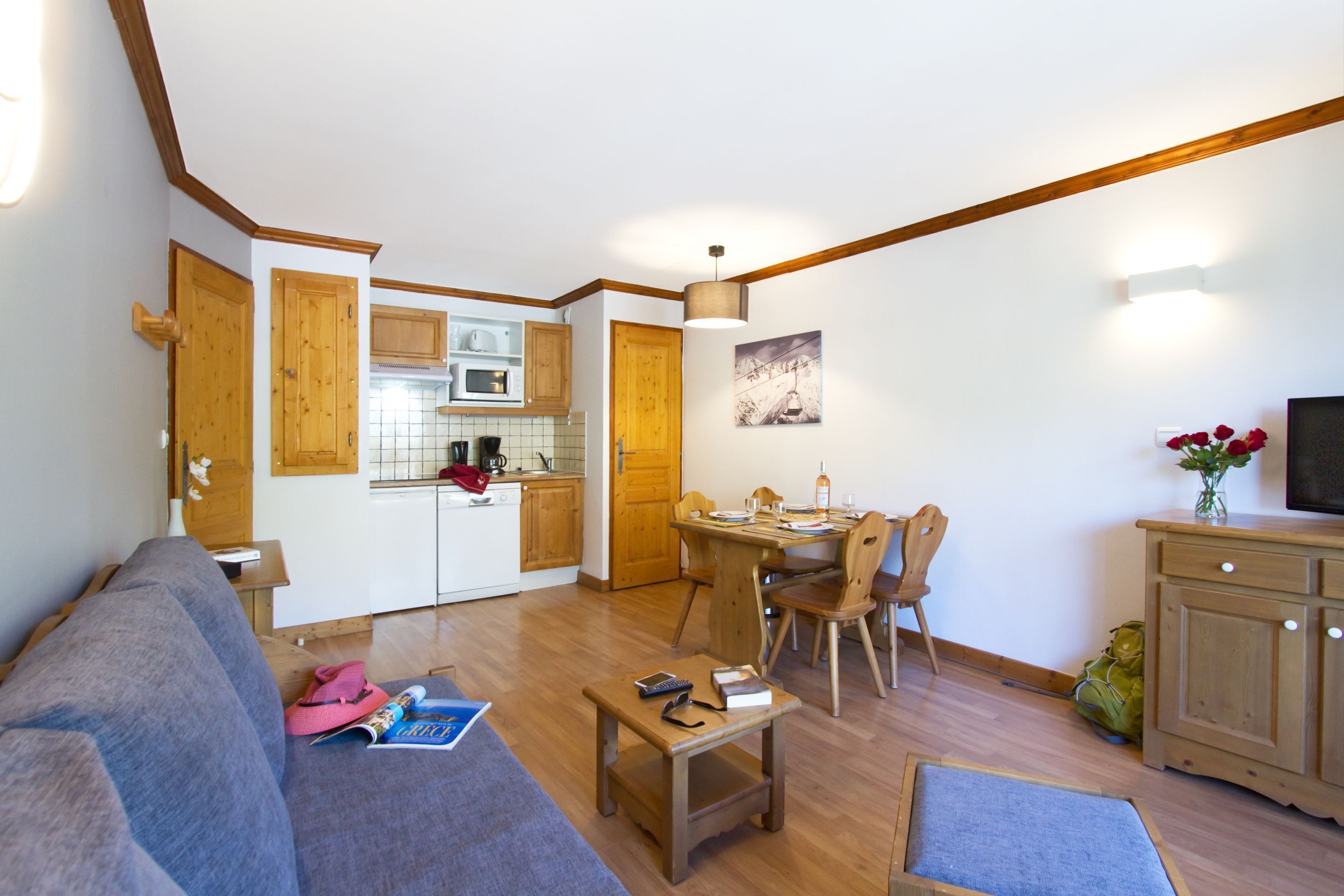 A compact living space with a kitchenette, dining area, and seating.