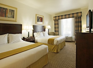 A hotel room with two beds, a desk, a television, and a window with curtains. - Holiday Inn Express & Suites Childress by IHG (Childress)