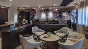 A modern lobby with a reception desk, seating area, and a decorative wall.